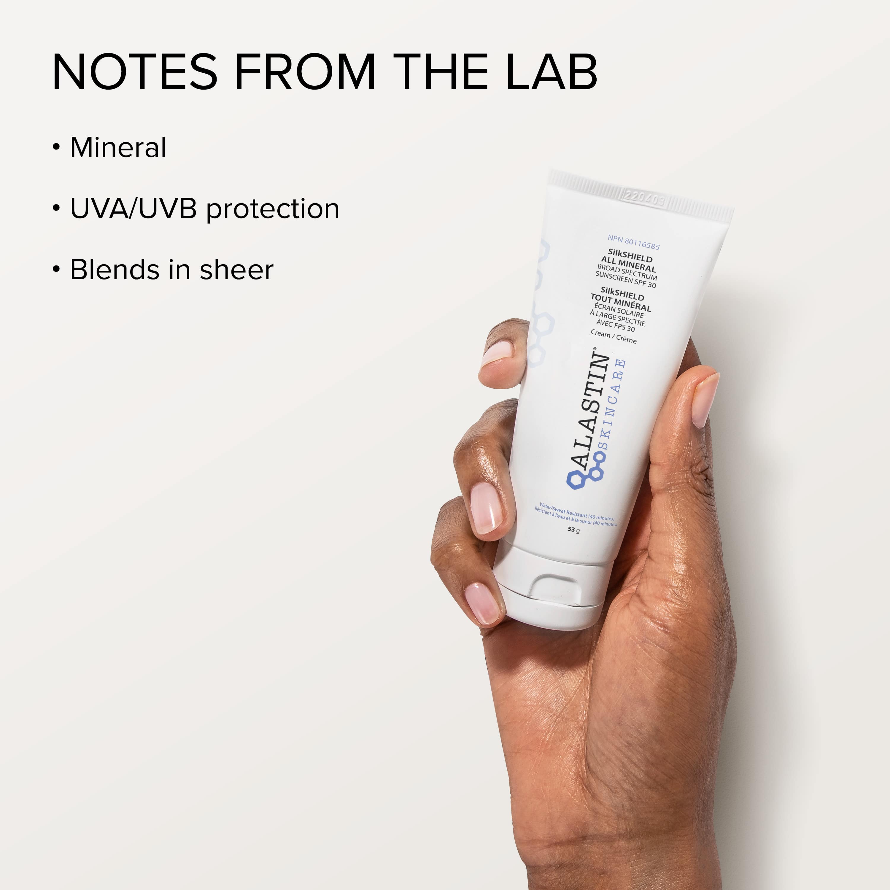 Hand holding a tube of Alastin skincare product with text about UVA/UVB protection on a light - background. Available in Orangeville