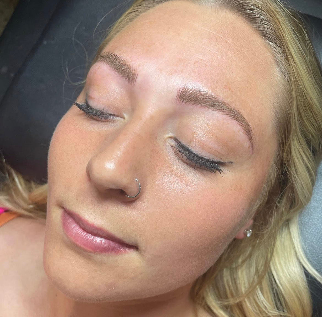 Image of client getting microblading done to her eyebrows